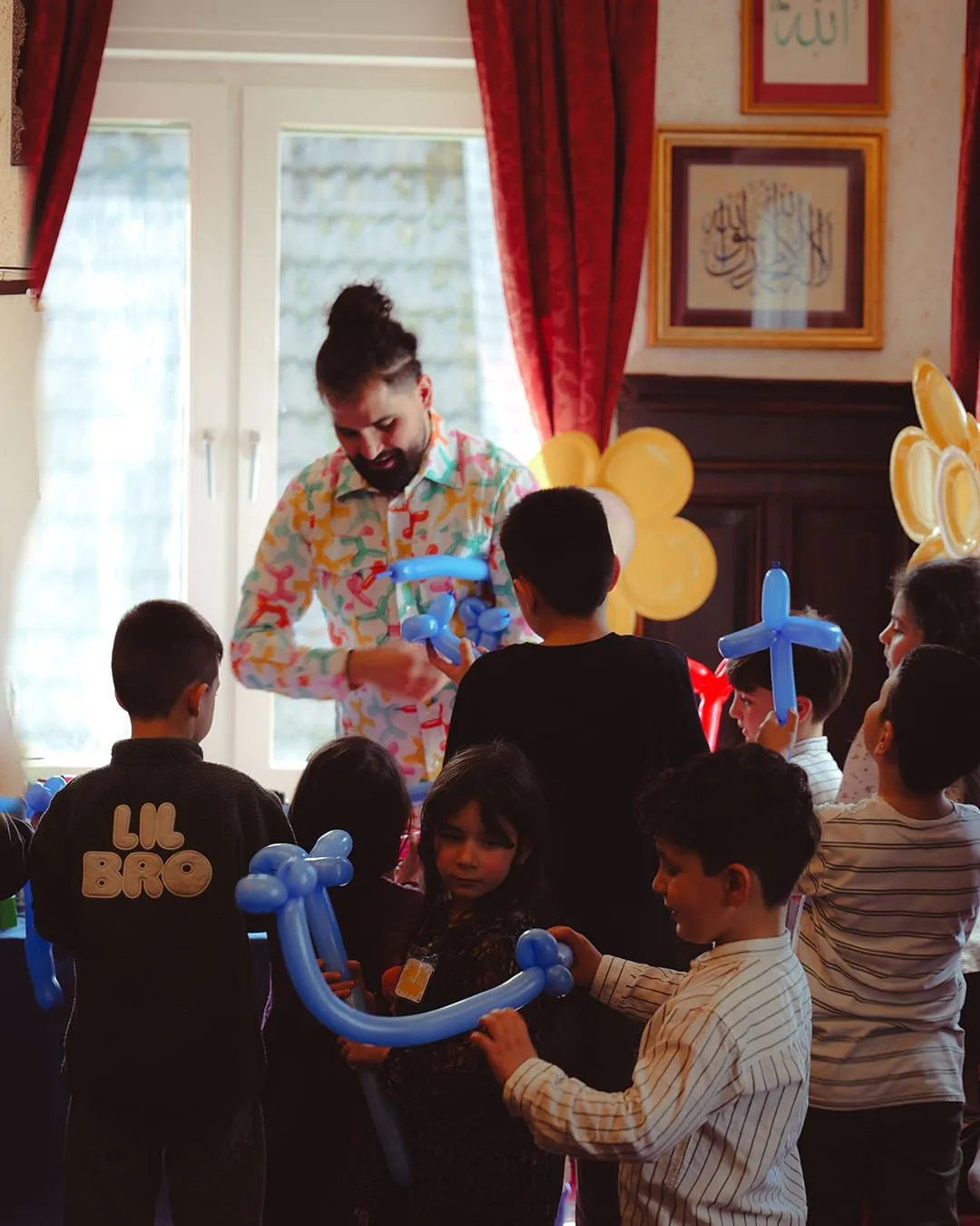Ein Ballonkünstler formt Figuren, die Kinder schauen zu