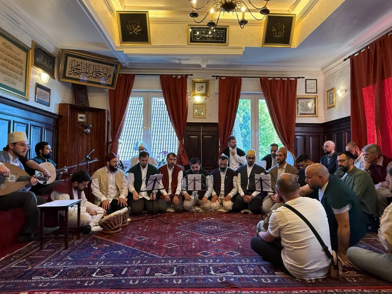 Meşk-Abend im Saal des Vereinshauses: Musiker und Gäste sitzen im Kreis auf Teppichen (Mai 2025)